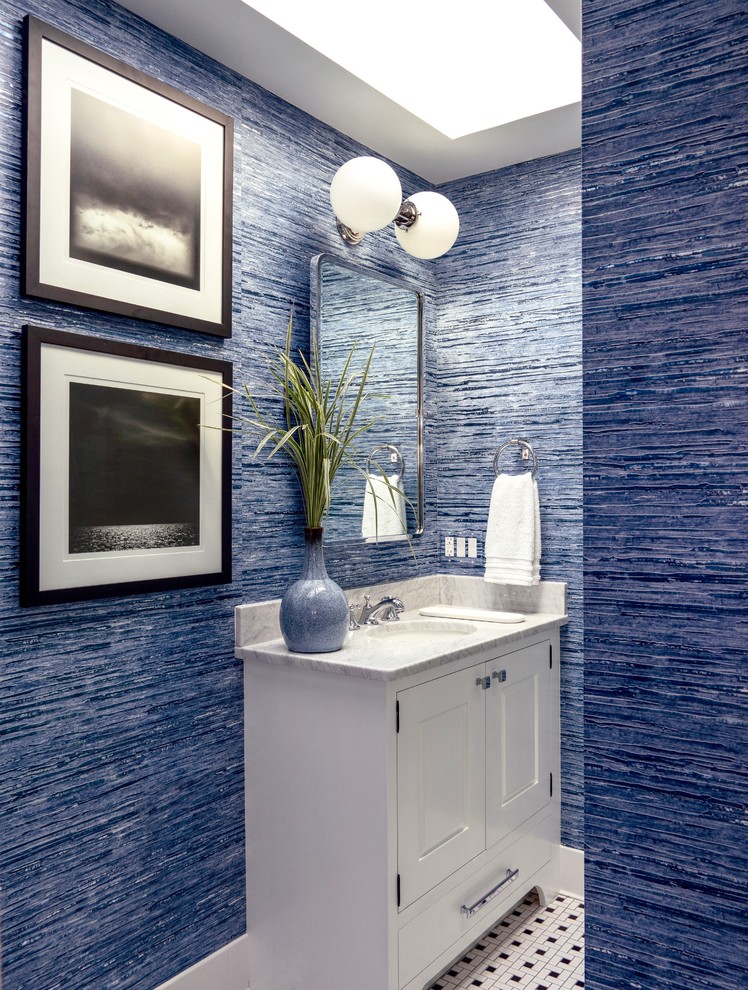 Idee per un bagno di servizio stile marino con ante con riquadro incassato, ante bianche, pareti blu, pavimento con piastrelle a mosaico, lavabo sottopiano, pavimento multicolore e top bianco