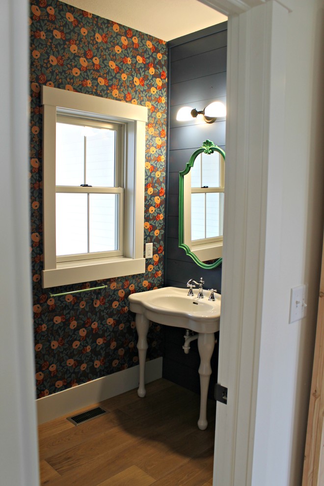 Idée de décoration pour un petit WC et toilettes champêtre avec WC séparés, un mur bleu, un sol en bois brun, un plan vasque et un sol marron.