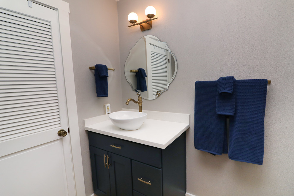 Cette photo montre un petit WC et toilettes moderne avec un placard à porte plane, des portes de placard bleues, WC séparés, un carrelage blanc, des carreaux de céramique, un mur gris, un sol en bois brun, une vasque, un plan de toilette en quartz modifié et un plan de toilette blanc.