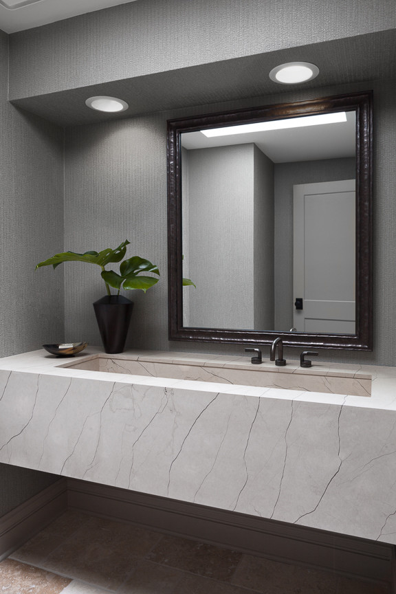 Inspiration for a small contemporary cloakroom in Chicago with freestanding cabinets, beige cabinets, a two-piece toilet, grey walls, travertine flooring, a trough sink, limestone worktops and multi-coloured floors.