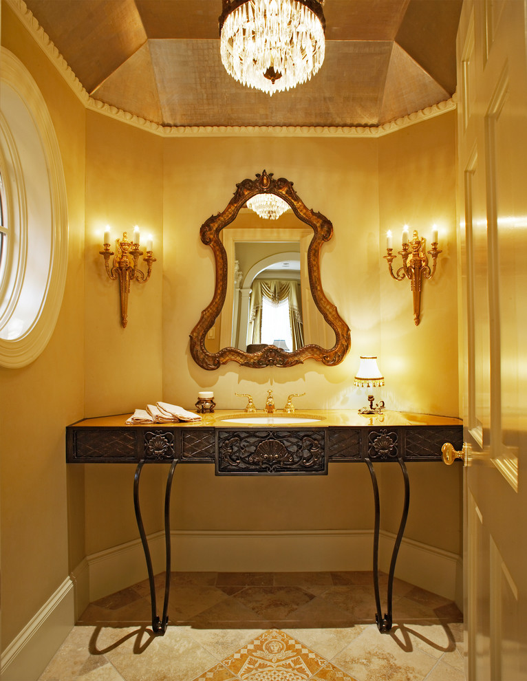 Esempio di un bagno di servizio classico con lavabo sottopiano e piastrelle beige