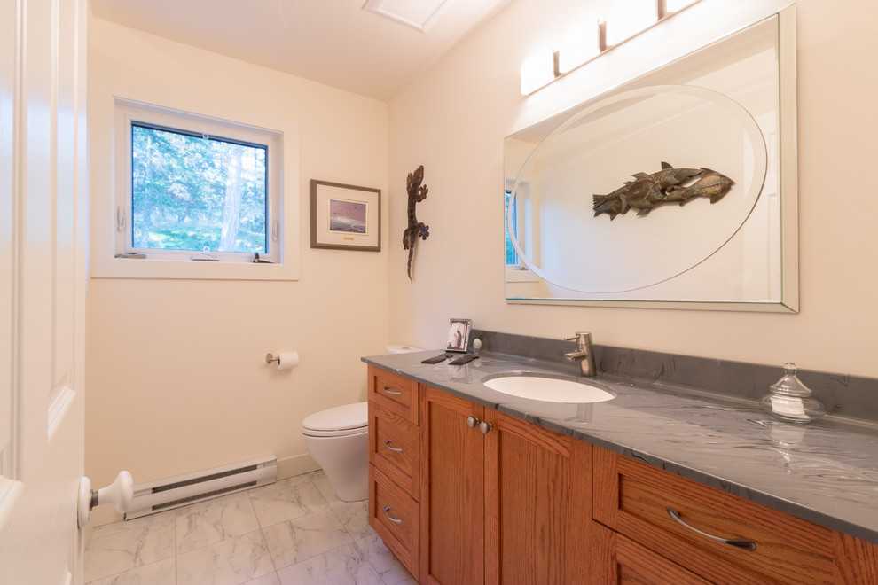 Medium sized traditional cloakroom in Vancouver with a submerged sink, shaker cabinets, medium wood cabinets, solid surface worktops, a two-piece toilet, grey tiles, porcelain tiles, white walls and porcelain flooring.