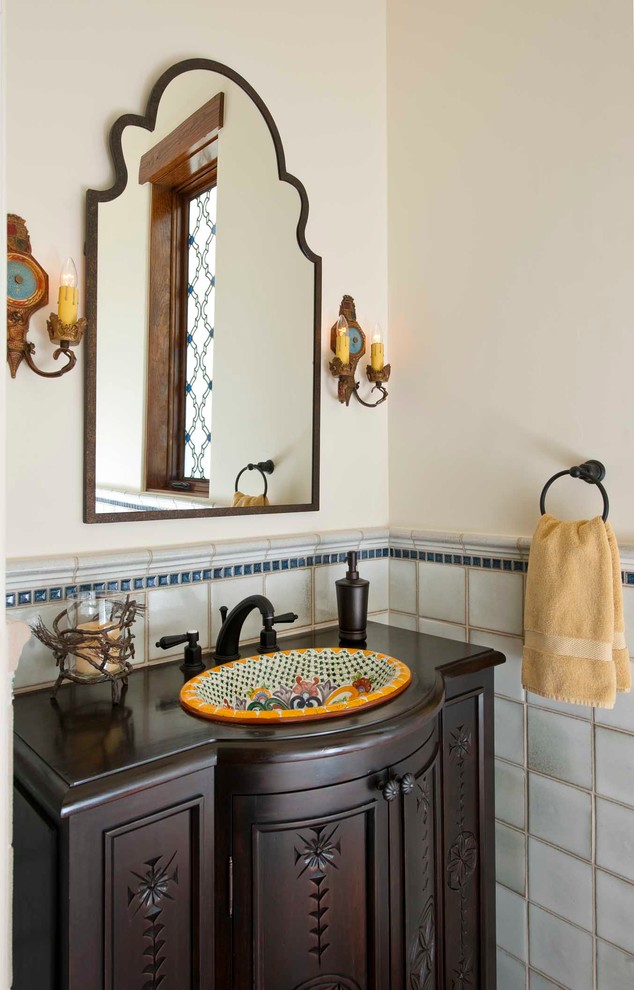 Ispirazione per un bagno di servizio mediterraneo con lavabo da incasso, consolle stile comò, ante in legno bruno, pareti bianche e piastrelle blu