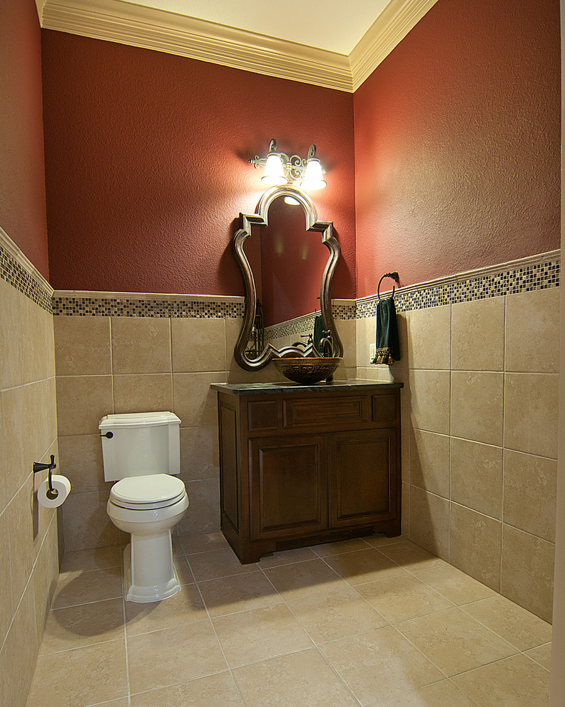 Cette image montre un WC et toilettes traditionnel en bois brun de taille moyenne avec une vasque, un placard avec porte à panneau surélevé, WC à poser, un carrelage beige, des carreaux de céramique, un mur rouge et un sol en carrelage de céramique.