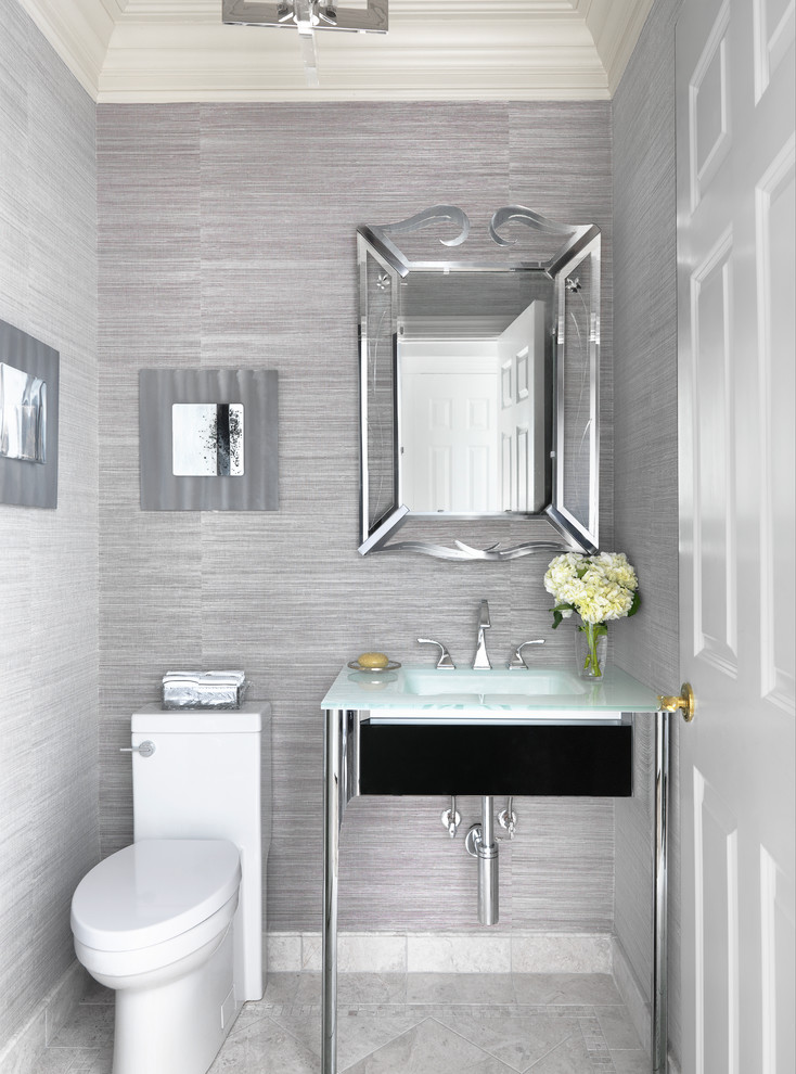 Inspiration for a transitional gray floor powder room remodel in St Louis with a one-piece toilet, gray walls, a console sink, glass countertops and blue countertops