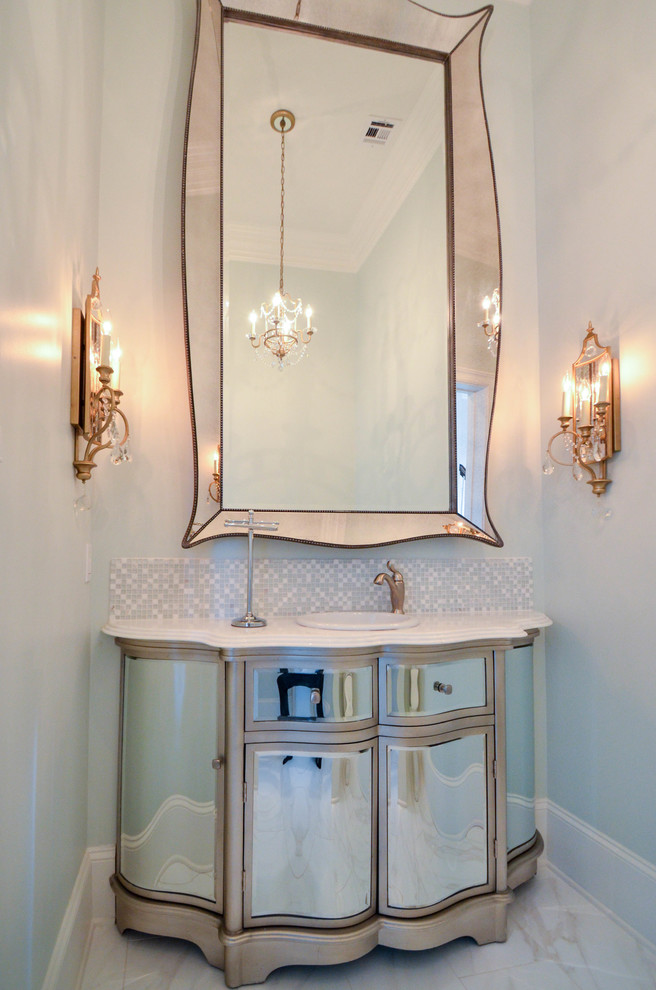 Small elegant powder room photo in New Orleans with glass-front cabinets