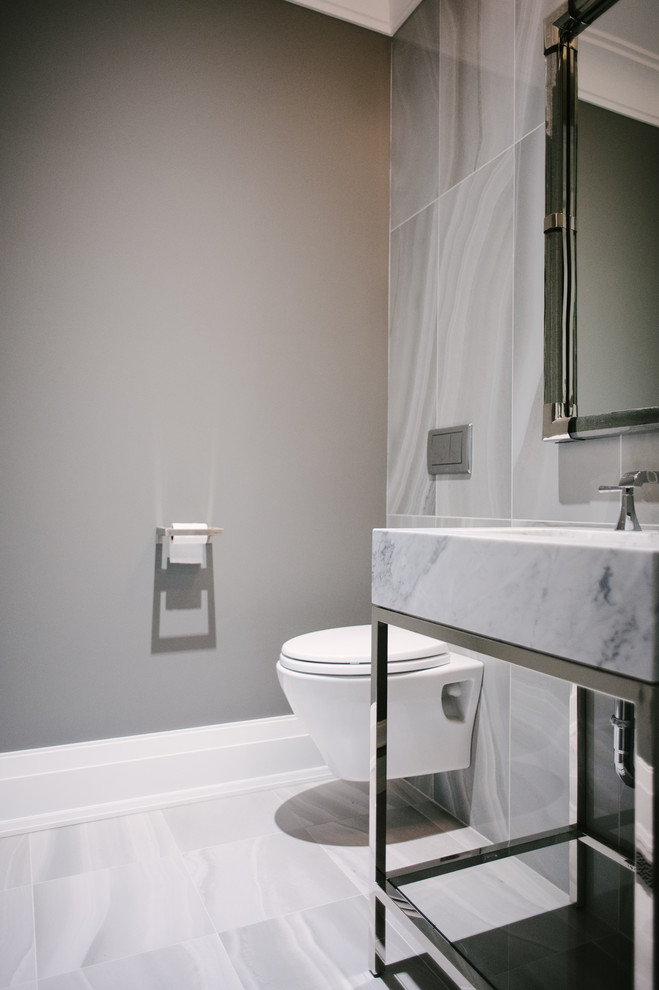 Cette photo montre un petit WC suspendu tendance avec un carrelage gris, des carreaux de porcelaine, un mur gris, un sol en carrelage de porcelaine, un lavabo encastré, un plan de toilette en marbre, un sol gris et un plan de toilette gris.