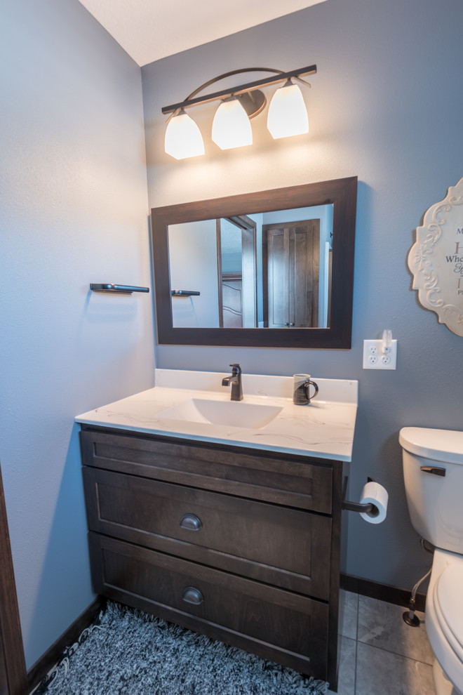Design ideas for a large rustic cloakroom in Minneapolis with shaker cabinets, dark wood cabinets, a two-piece toilet, grey walls, porcelain flooring, an integrated sink, marble worktops and beige floors.