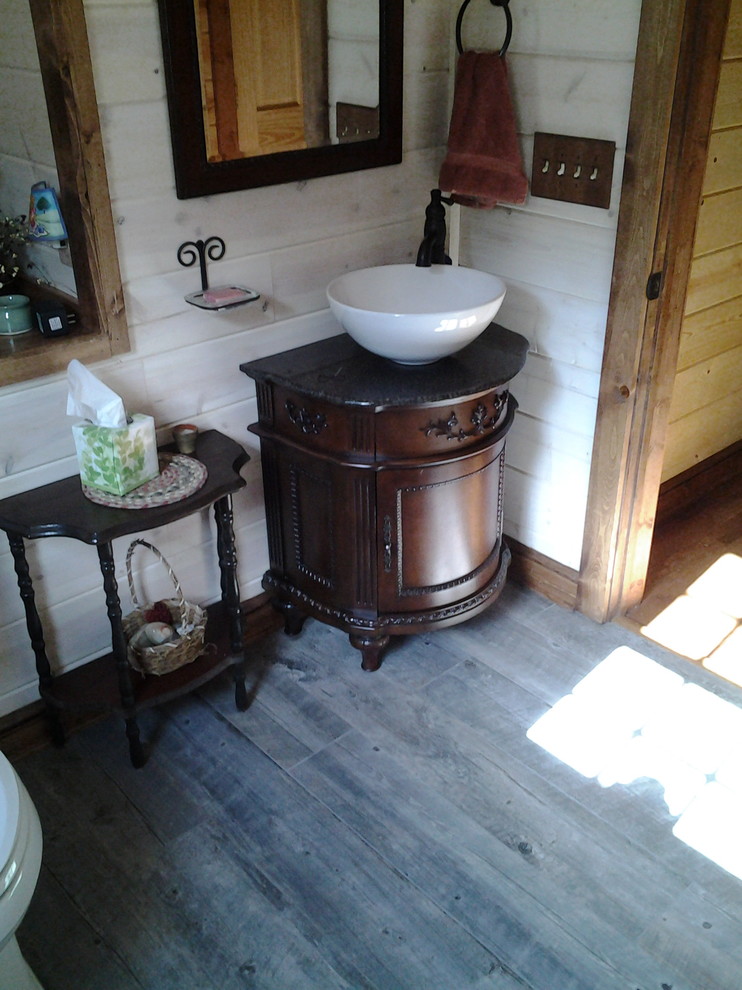 Ispirazione per un bagno di servizio rustico di medie dimensioni con ante a filo, ante in legno bruno, pareti bianche, pavimento in legno massello medio, lavabo a bacinella e top in granito