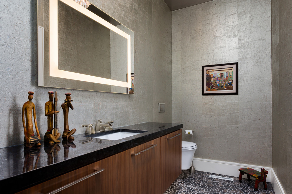 Источник вдохновения для домашнего уюта: туалет в современном стиле с плоскими фасадами, темными деревянными фасадами, серыми стенами, полом из галечной плитки, врезной раковиной, разноцветным полом и черной столешницей