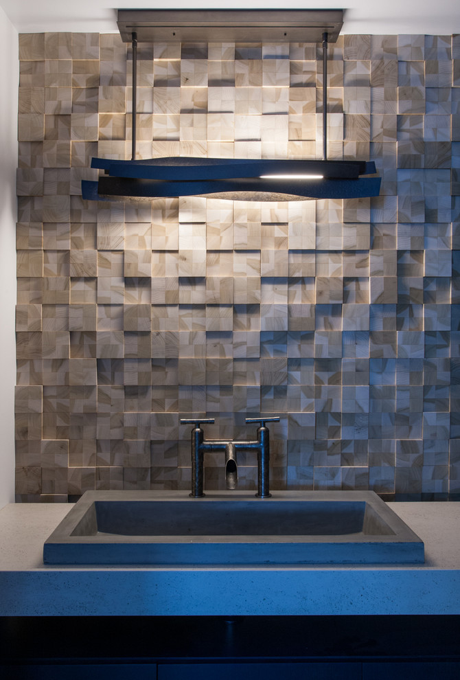 Пример оригинального дизайна: туалет в стиле модернизм с серой плиткой, цементной плиткой и столешницей из известняка