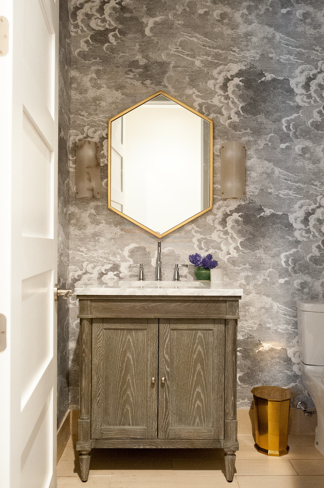 Small traditional cloakroom in Detroit with freestanding cabinets, a submerged sink, beige floors, white worktops, medium wood cabinets, a one-piece toilet, multi-coloured walls, porcelain flooring and marble worktops.