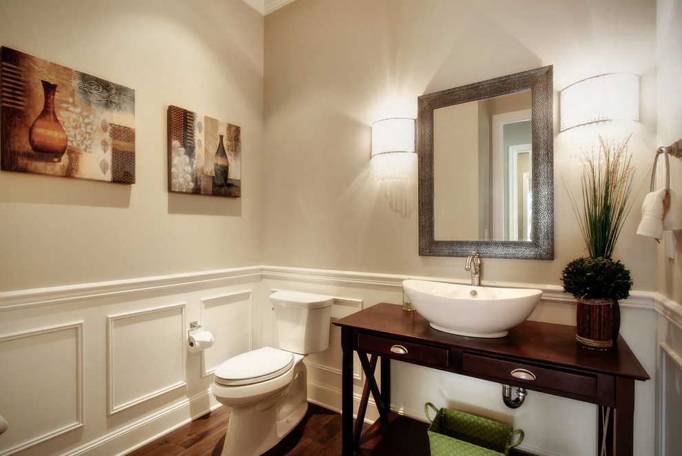 Idées déco pour un WC et toilettes craftsman en bois foncé de taille moyenne avec un placard en trompe-l'oeil, un carrelage blanc, un mur beige, parquet foncé, une vasque, un plan de toilette en bois et un sol marron.
