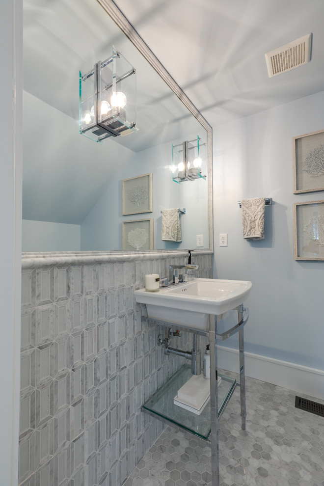 Bild på ett mellanstort funkis vit vitt toalett, med vit kakel, marmorkakel, blå väggar, marmorgolv, ett väggmonterat handfat, bänkskiva i kvarts och vitt golv