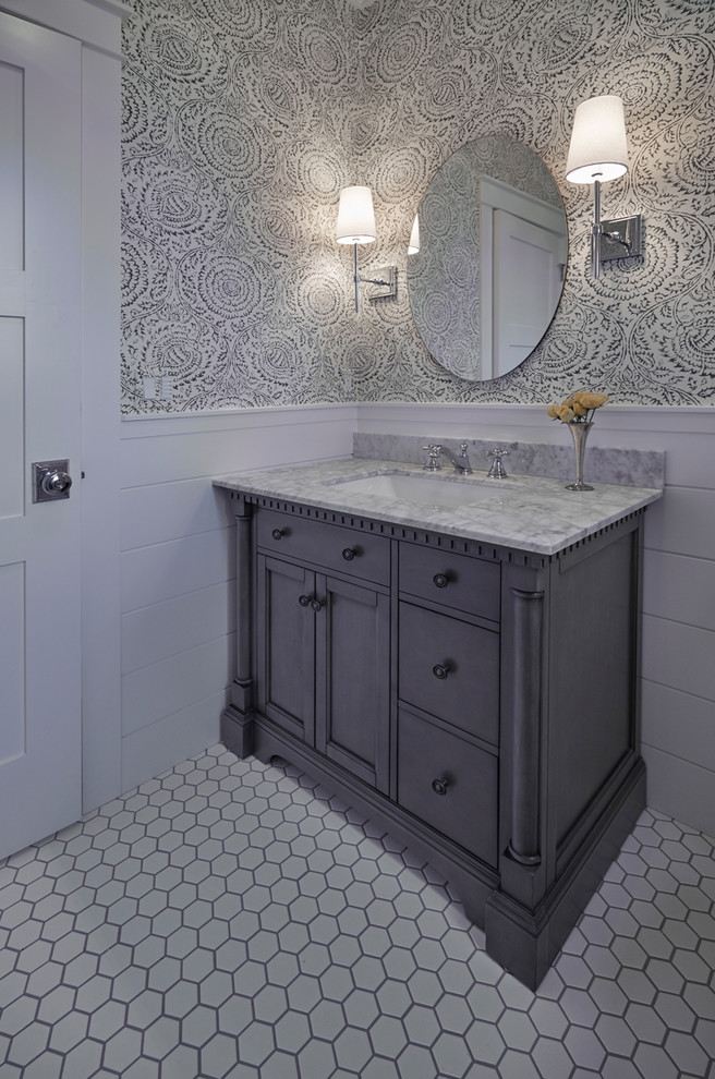 Inredning av ett amerikanskt mellanstort toalett, med möbel-liknande, grå skåp, en toalettstol med hel cisternkåpa, flerfärgade väggar, klinkergolv i porslin, ett undermonterad handfat, marmorbänkskiva och vitt golv