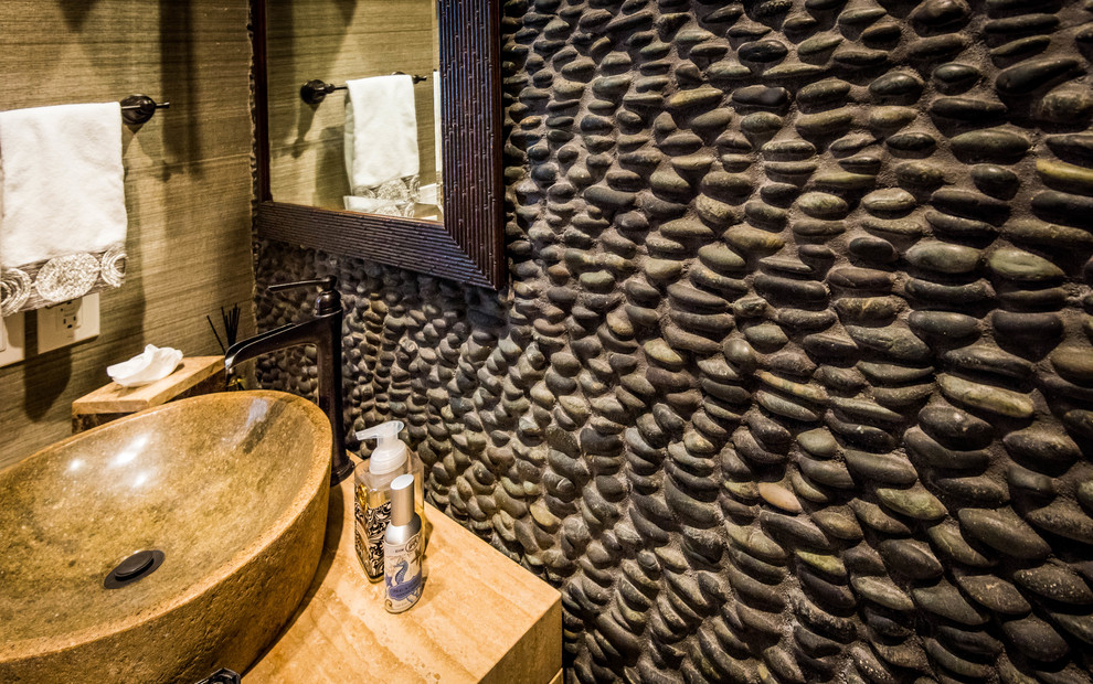 Cette photo montre un petit WC et toilettes montagne en bois clair avec un mur beige, une vasque et un plan de toilette en travertin.