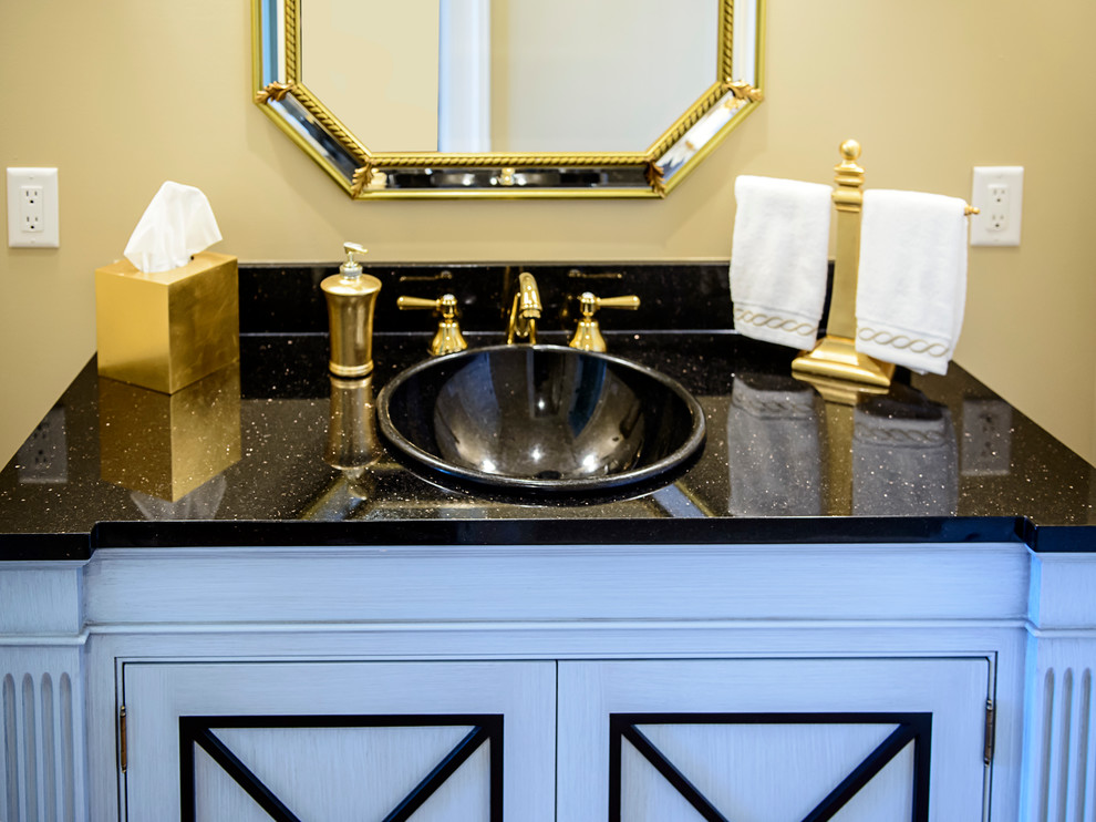 Idee per un bagno di servizio design con lavabo da incasso, ante con bugna sagomata, top in granito, pareti beige, ante blu e top nero