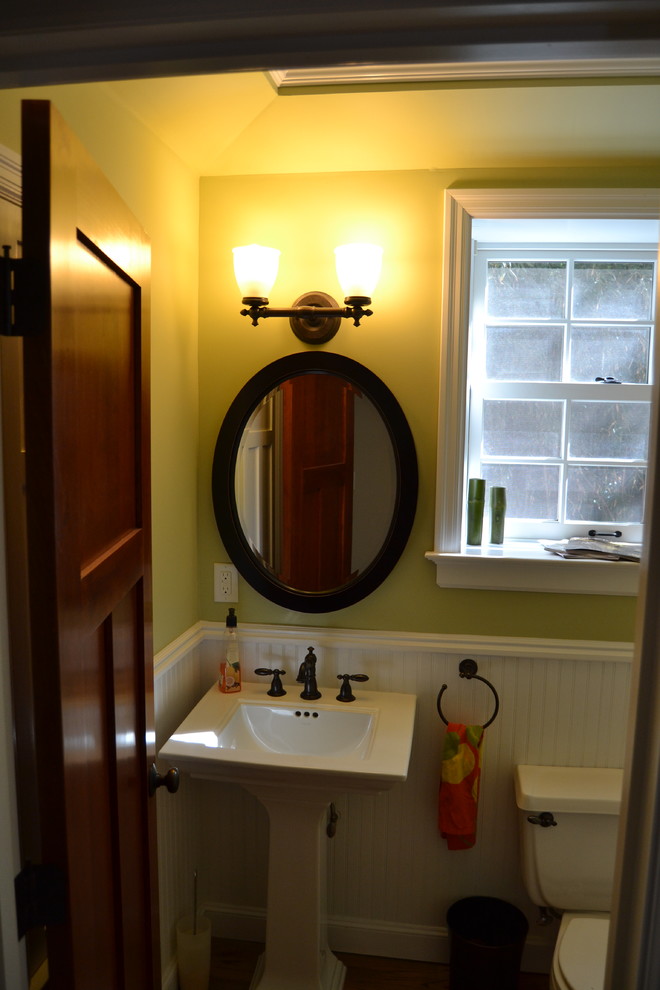 Idee per un piccolo bagno di servizio american style con lavabo a colonna, pareti verdi e pavimento in legno massello medio