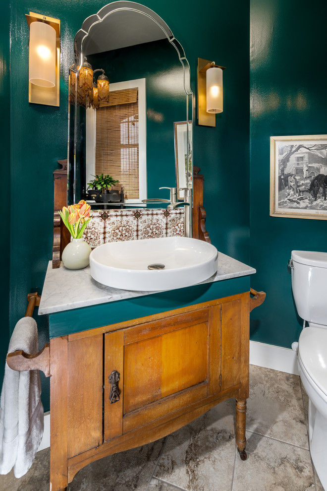 Inspiration for a small classic cloakroom in Other with marble worktops, freestanding cabinets, medium wood cabinets, a two-piece toilet, green walls, a vessel sink and beige floors.