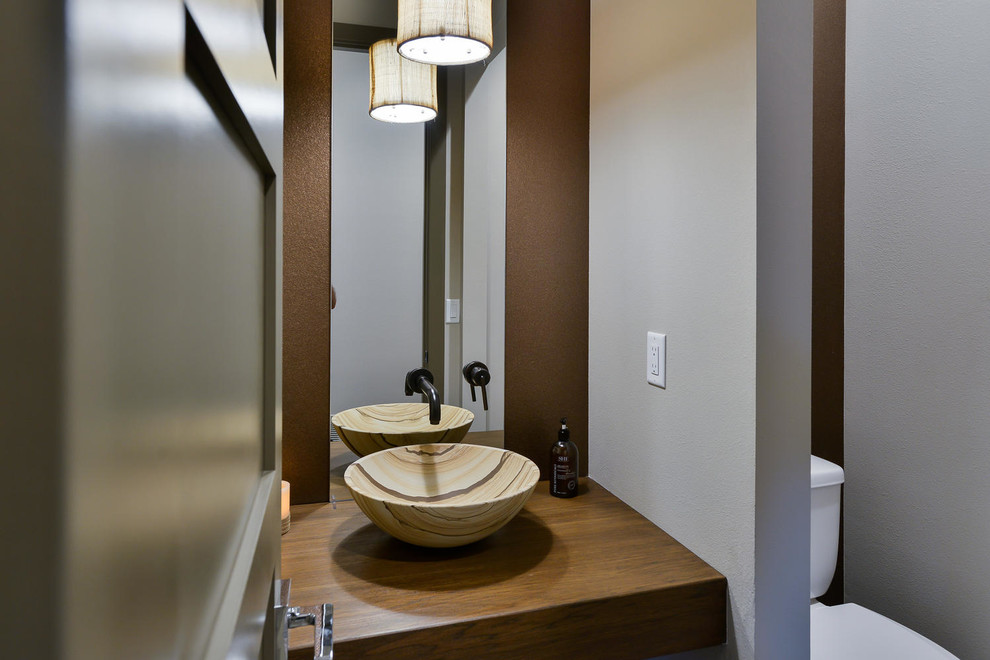Immagine di un bagno di servizio minimal di medie dimensioni con WC a due pezzi, pareti grigie, lavabo a bacinella e top in legno