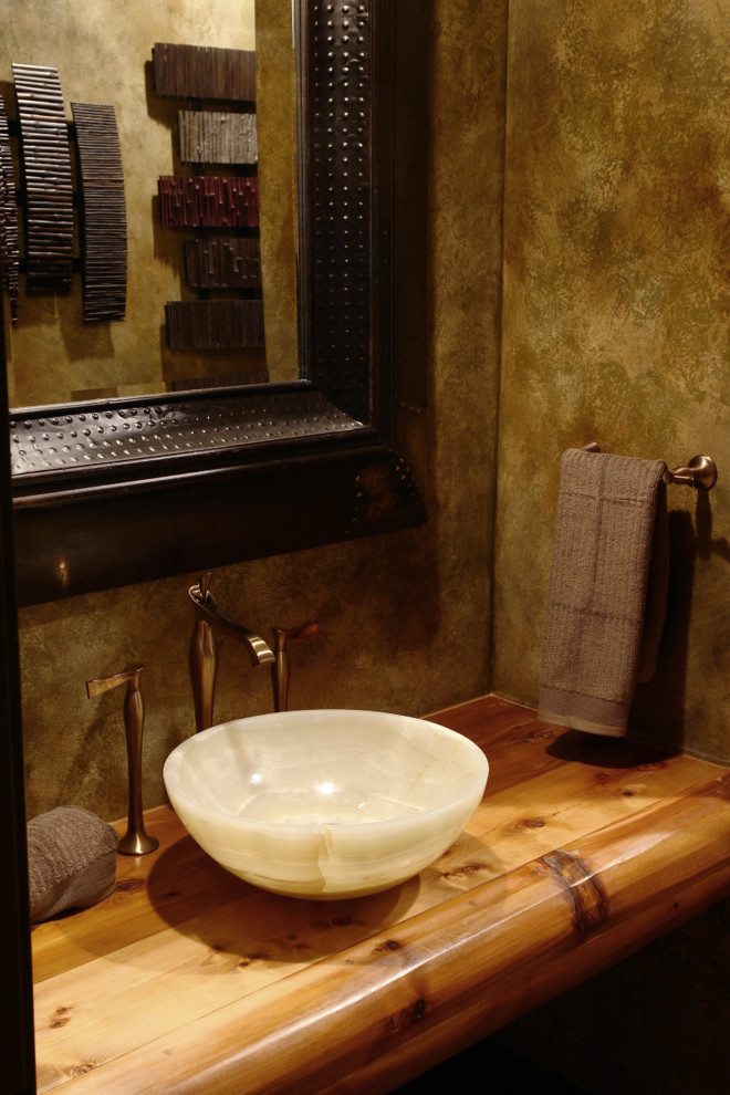 Ispirazione per un bagno di servizio stile rurale di medie dimensioni con lavabo a bacinella, top in legno, piastrelle beige, pareti marroni e top marrone