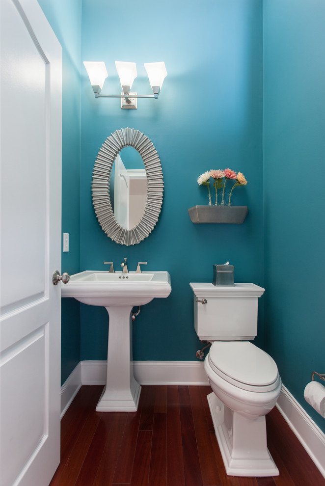 Ispirazione per un bagno di servizio chic di medie dimensioni con WC a due pezzi, pareti blu, parquet scuro e lavabo a colonna