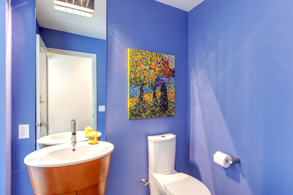 Esempio di un bagno di servizio design con lavabo da incasso, consolle stile comò, ante in legno scuro, WC a due pezzi e pareti blu