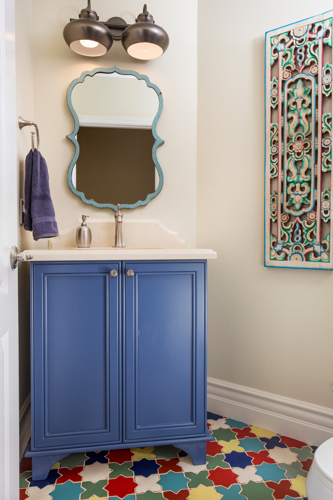 Medium sized mediterranean cloakroom in San Diego with recessed-panel cabinets, blue cabinets, a one-piece toilet, multi-coloured tiles, beige walls, terracotta flooring, a submerged sink and engineered stone worktops.