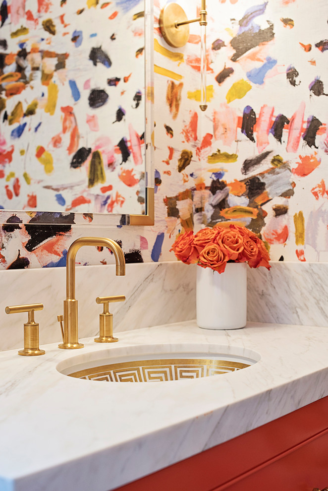Inredning av ett eklektiskt toalett, med orange skåp och marmorbänkskiva