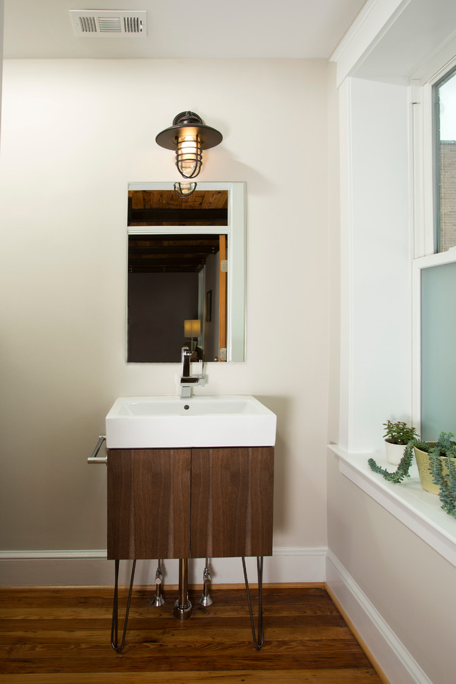 Example of a mid-sized urban medium tone wood floor powder room design in DC Metro with flat-panel cabinets, dark wood cabinets, beige walls and a vessel sink
