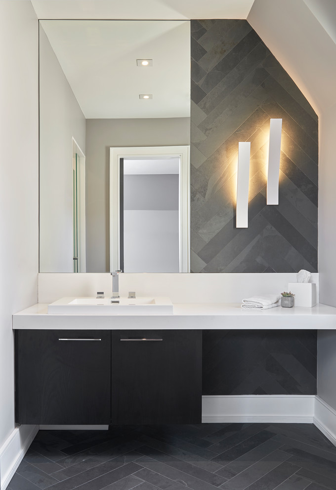 This is an example of a medium sized contemporary cloakroom in Toronto with flat-panel cabinets, black cabinets, grey tiles, white walls, slate flooring, a vessel sink, solid surface worktops and grey floors.