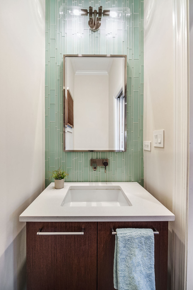 Small contemporary cloakroom in Chicago with flat-panel cabinets, glass tiles, a submerged sink, dark wood cabinets, green tiles, white walls, white worktops, a one-piece toilet, dark hardwood flooring and brown floors.