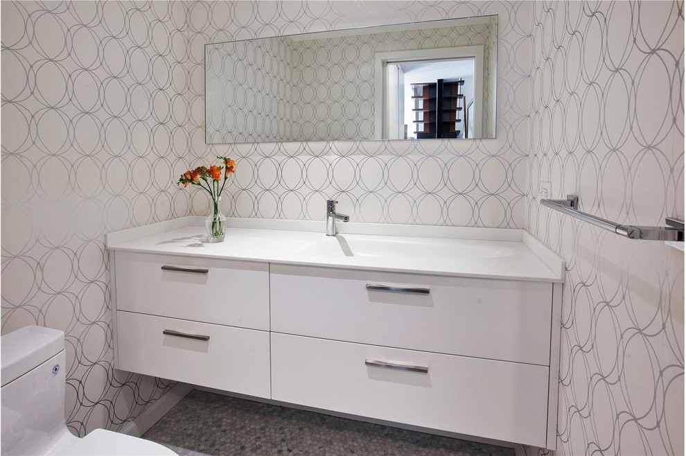 Powder room - small contemporary ceramic tile powder room idea in Chicago with an integrated sink, flat-panel cabinets, white cabinets, solid surface countertops, a two-piece toilet and white walls