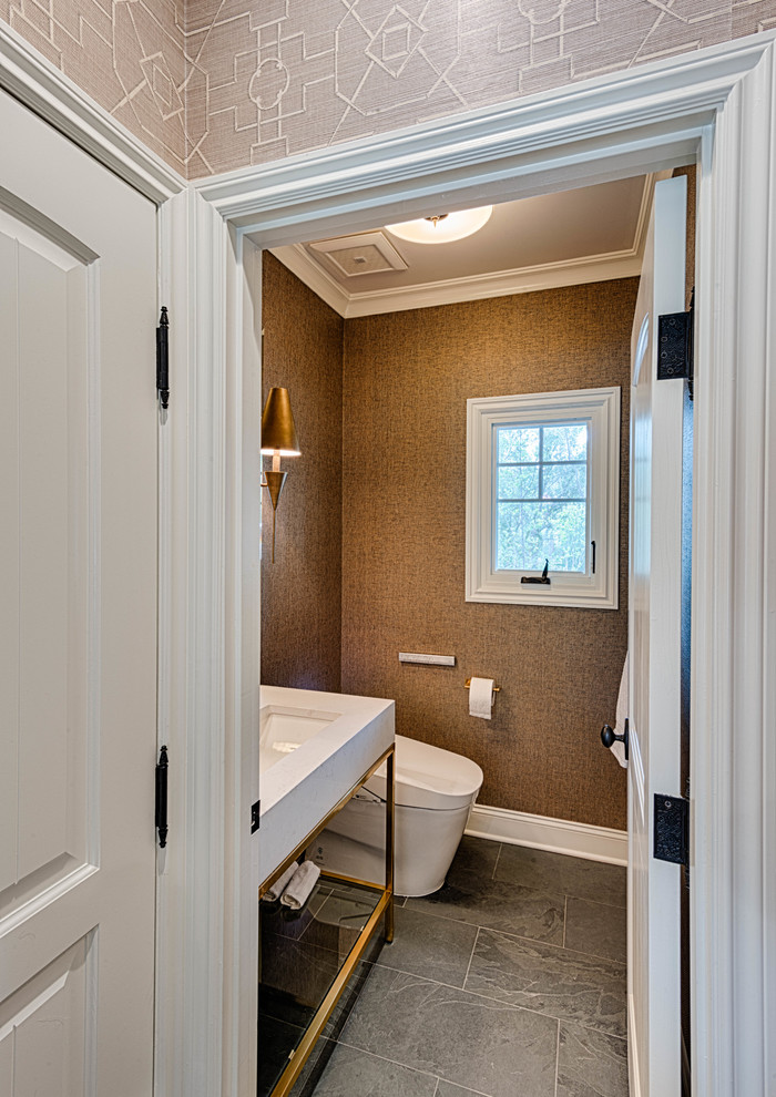 Exemple d'un petit WC et toilettes chic avec un placard sans porte, WC à poser, un mur marron, un sol en ardoise, un lavabo suspendu, un plan de toilette en surface solide, un sol gris et un plan de toilette blanc.