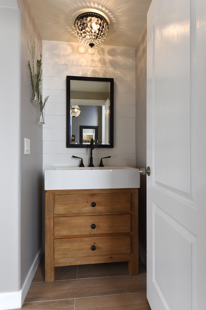 Idée de décoration pour un petit WC et toilettes champêtre avec un placard à porte plane, des portes de placard marrons, un mur gris, un sol en bois brun, un lavabo intégré et un sol marron.