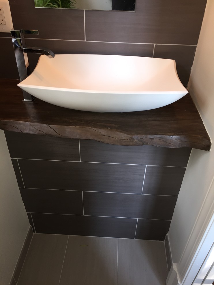 Small transitional gray tile and porcelain tile porcelain tile powder room photo in DC Metro with gray walls, wood countertops and a vessel sink