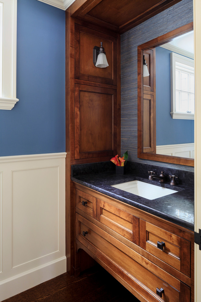 Imagen de aseo clásico pequeño con lavabo bajoencimera, paredes azules y suelo de madera oscura
