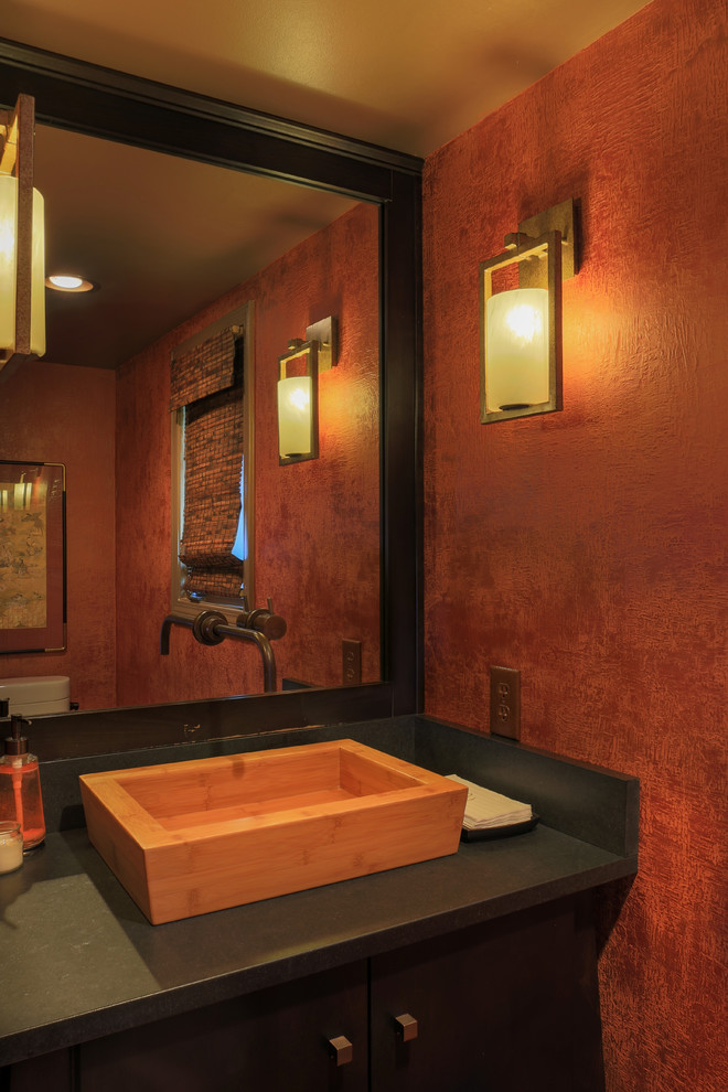Idées déco pour un petit WC et toilettes moderne en bois foncé avec un placard en trompe-l'oeil, WC à poser, un mur orange, parquet foncé, une vasque et un plan de toilette en granite.