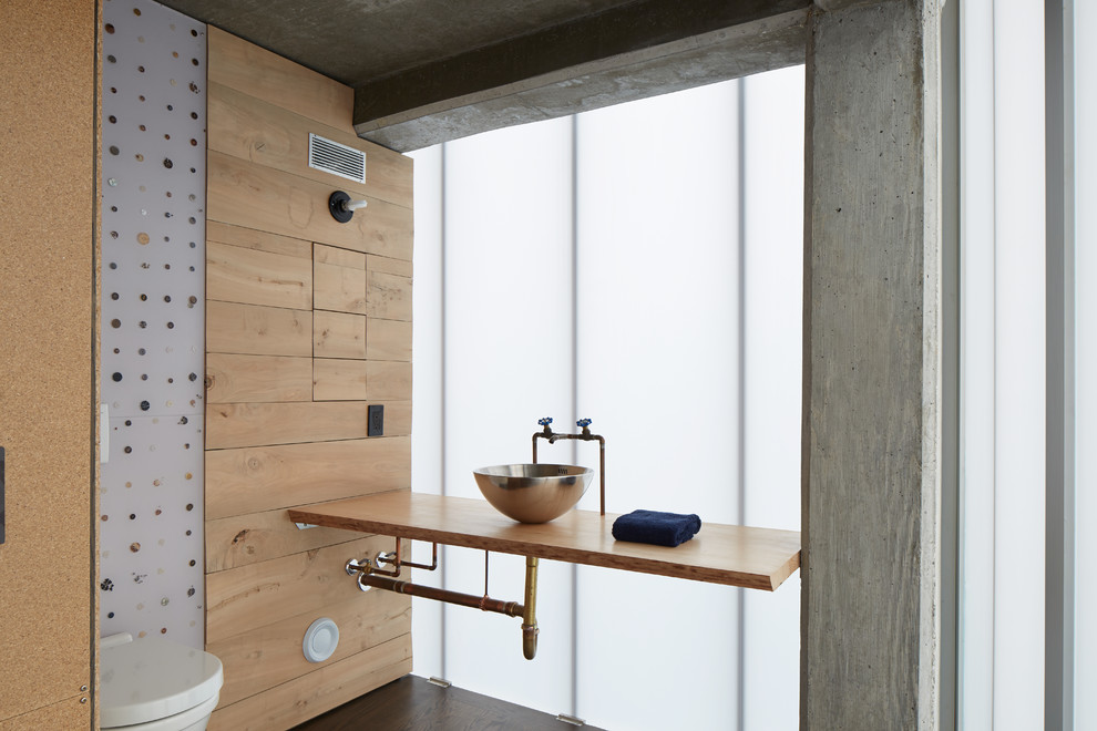 Mittelgroße Industrial Gästetoilette mit Aufsatzwaschbecken, Waschtisch aus Holz, dunklem Holzboden und brauner Waschtischplatte in New York