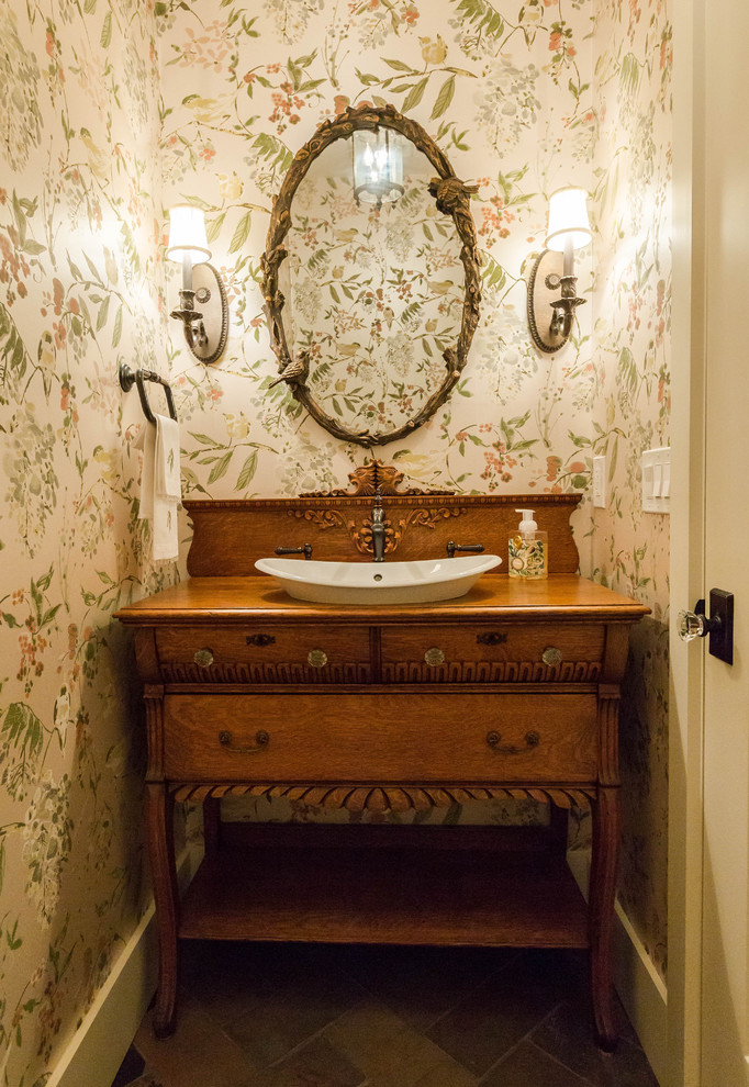 Kleine Klassische Gästetoilette mit verzierten Schränken, hellbraunen Holzschränken, Wandtoilette mit Spülkasten, Schieferboden, Aufsatzwaschbecken und Waschtisch aus Holz in New York