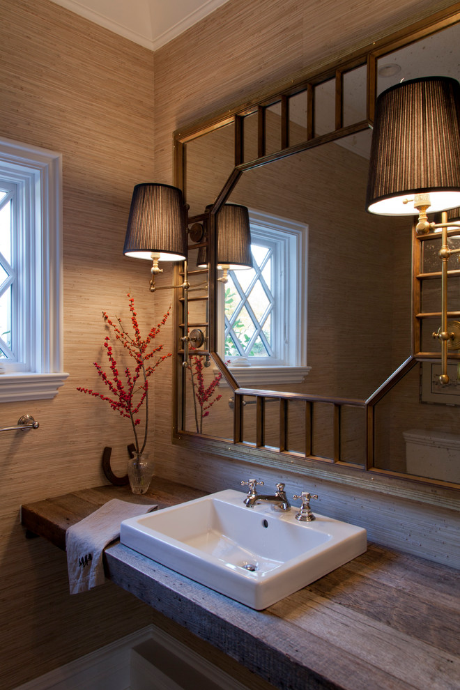 Пример оригинального дизайна: туалет в классическом стиле с накладной раковиной, столешницей из дерева и коричневой столешницей