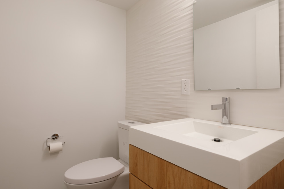 Inspiration pour un WC et toilettes design en bois brun avec un placard à porte plane, un carrelage blanc, des carreaux de céramique, un mur blanc, une grande vasque et un plan de toilette en quartz.