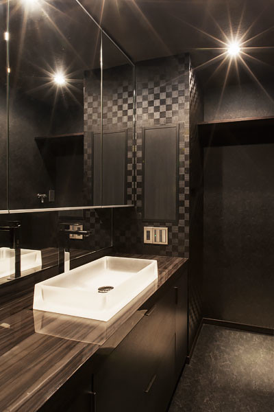 Example of a mid-sized trendy black tile slate floor powder room design in Orange County with a drop-in sink, beaded inset cabinets, dark wood cabinets and black walls