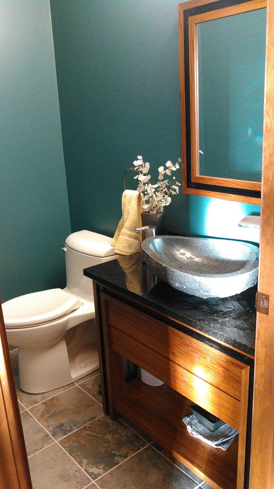 Cette photo montre un petit WC et toilettes chic en bois brun avec un placard à porte plane, WC à poser, un mur bleu, une vasque, un plan de toilette en marbre, un sol marron et un sol en carrelage de céramique.