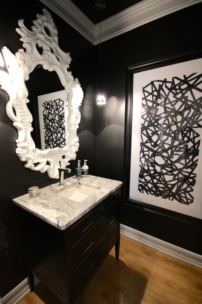 This is an example of a medium sized contemporary cloakroom in Atlanta with raised-panel cabinets, black cabinets, marble worktops, black walls, light hardwood flooring, a submerged sink, beige floors and grey worktops.