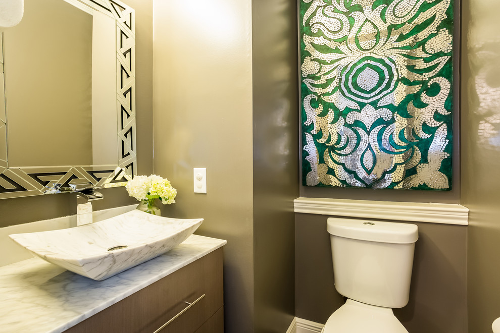 ヒューストンにある小さなトランジショナルスタイルのおしゃれなトイレ・洗面所 (フラットパネル扉のキャビネット、淡色木目調キャビネット、茶色い壁、ベッセル式洗面器、大理石の洗面台、白い洗面カウンター) の写真