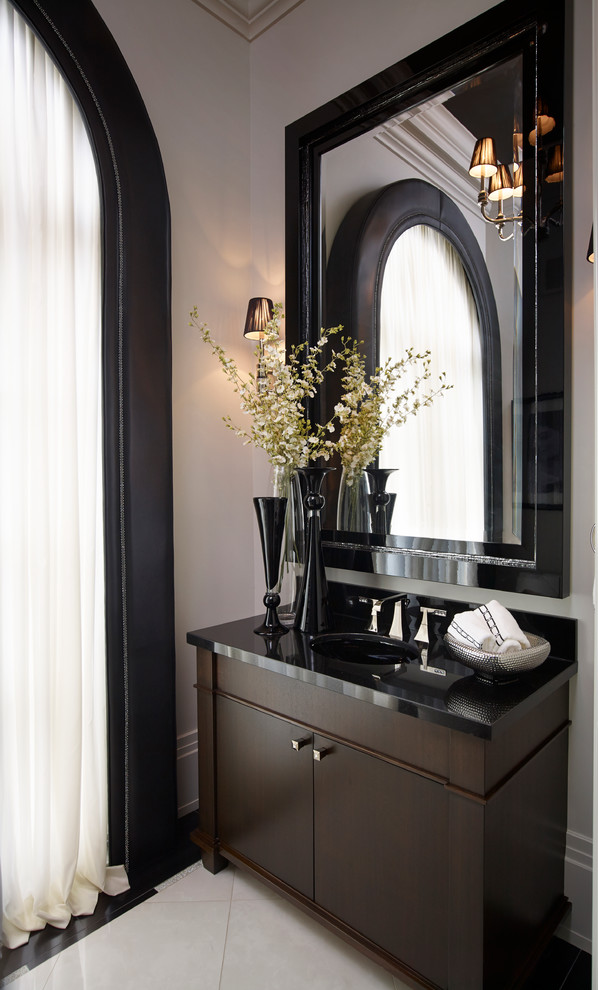 Mid-sized transitional marble floor powder room photo in Toronto with a one-piece toilet, an undermount sink, flat-panel cabinets, dark wood cabinets, white walls and solid surface countertops