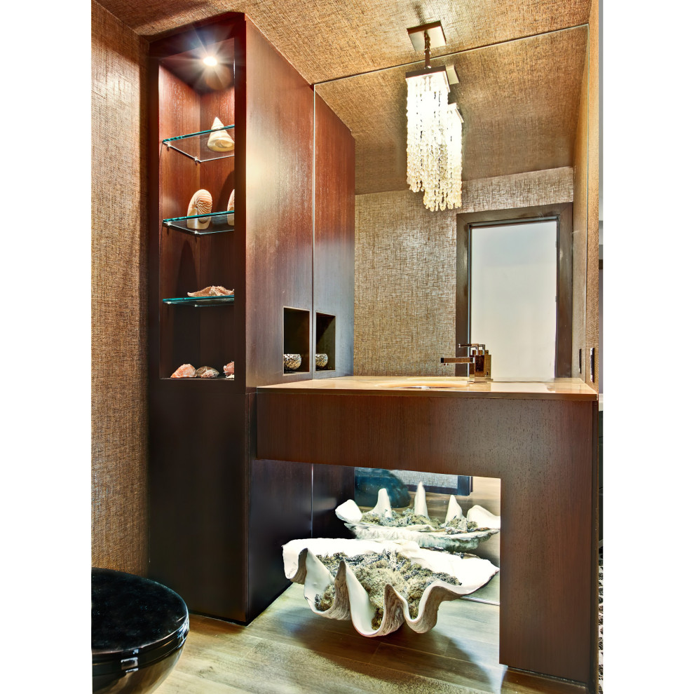 Foto på ett litet maritimt beige toalett, med släta luckor, bruna skåp, en toalettstol med hel cisternkåpa, ljust trägolv, ett undermonterad handfat, bänkskiva i onyx och beiget golv