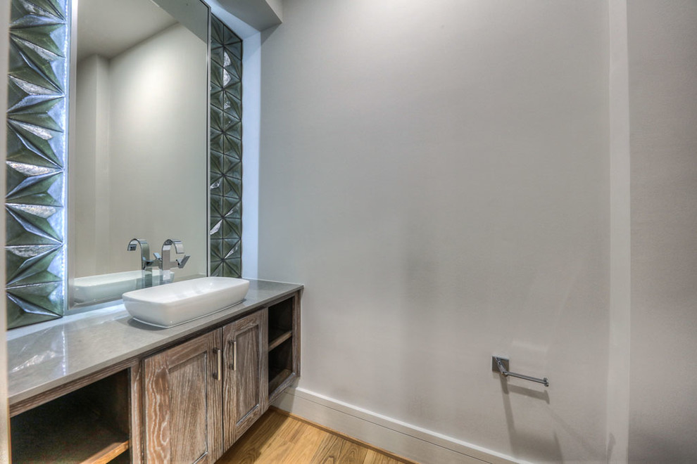 Exempel på ett stort modernt grå grått toalett, med luckor med infälld panel, skåp i slitet trä, en toalettstol med separat cisternkåpa, kakel i metall, vita väggar, ljust trägolv, ett fristående handfat, bänkskiva i kvarts och brunt golv