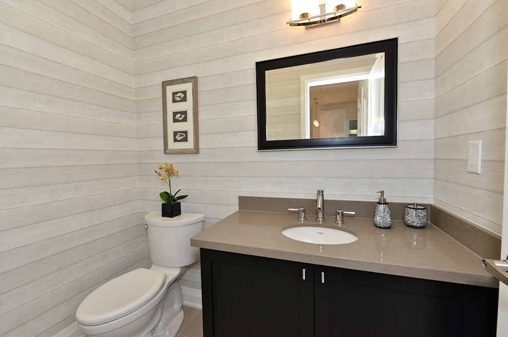 Exemple d'un WC et toilettes tendance en bois foncé de taille moyenne avec un placard à porte shaker, WC séparés, un mur gris, un sol en carrelage de porcelaine, un lavabo encastré et un plan de toilette en granite.